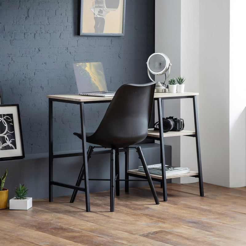 Modern office desk with black chair against a gray wall