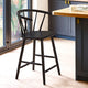 Black bar stool in a kitchen setting with a wooden table and blue cabinets.
