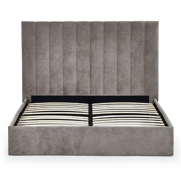 Gray upholstered bed with striped mattress on a white background