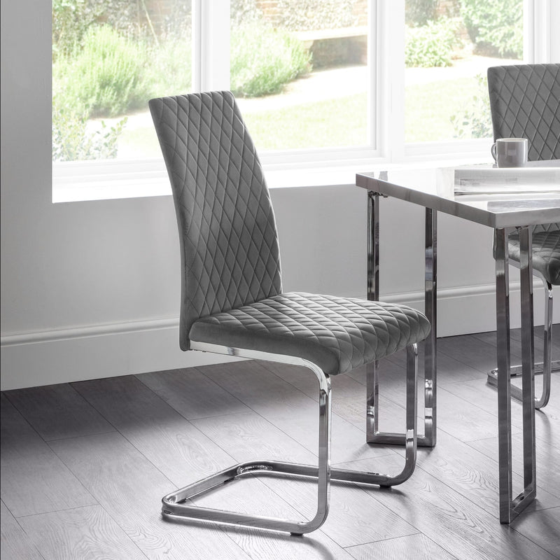 Gray quilted chair with chrome legs in a modern dining room setting
