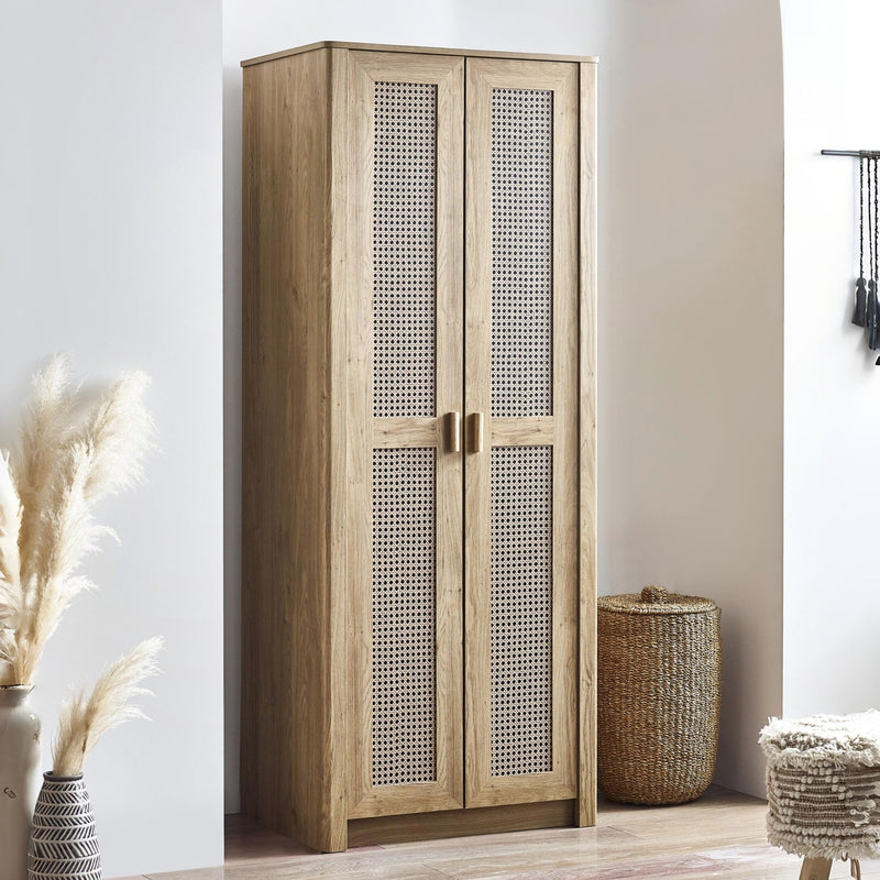 Wooden wardrobe with wicker door panels in a room setting.