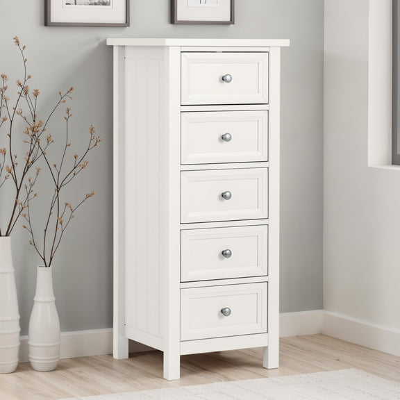 White dresser with four drawers in a room with gray walls and wooden flooring.