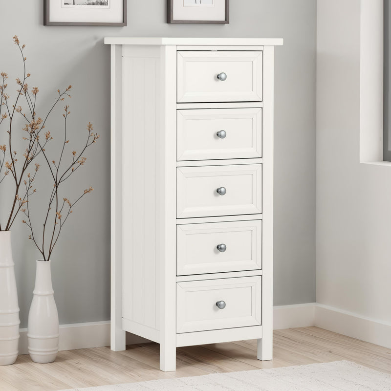 White dresser with four drawers in a room with gray walls and wooden flooring.