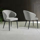 Two gray chairs with black legs on a light gray floor against a dark wooden paneled wall.