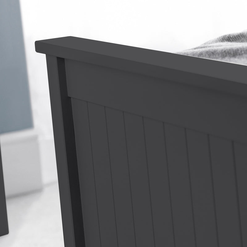 Close-up of a dark gray wooden bed frame against a light background