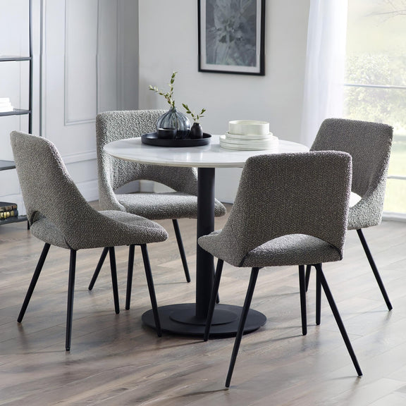 Round dining table with four gray chairs in a modern room.