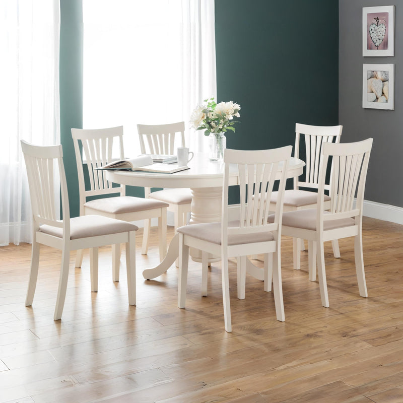 Dining room with a round table and six chairs on a wooden floor.