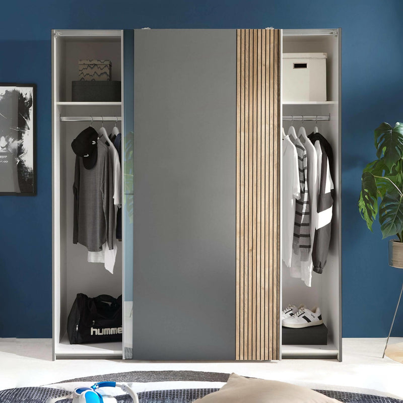 Closet with mirrored doors in a room with blue walls and a plant.