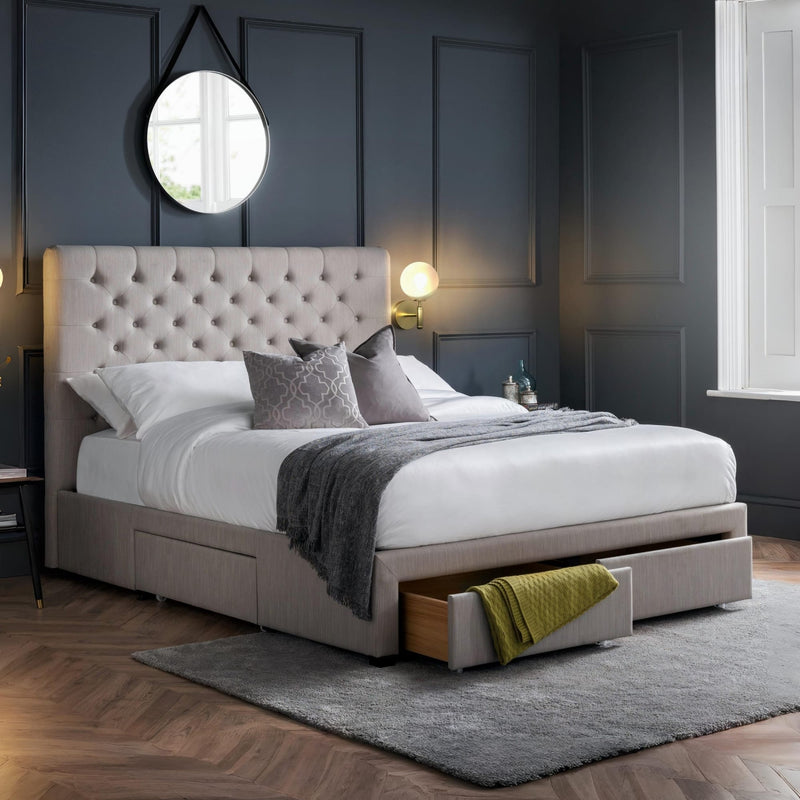 Modern bedroom with a gray upholstered bed and open drawer.