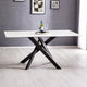 Modern dining table with black legs and white top in a room with gray walls and white floor.