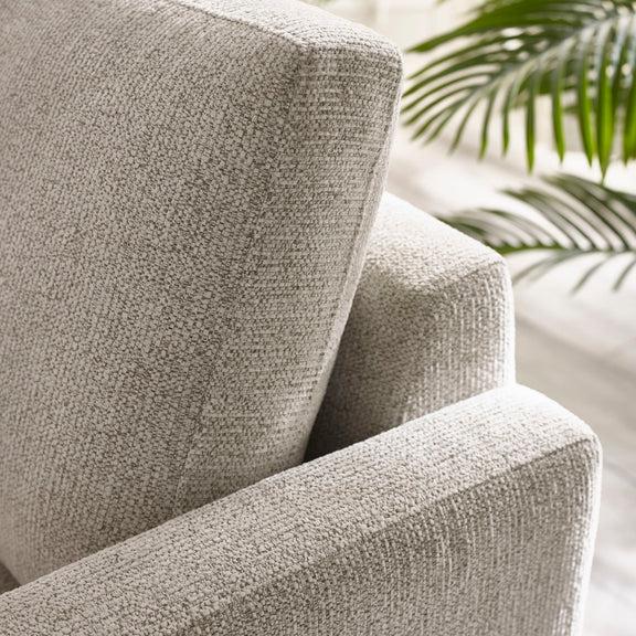 Close-up of a textured gray armchair with a blurred background