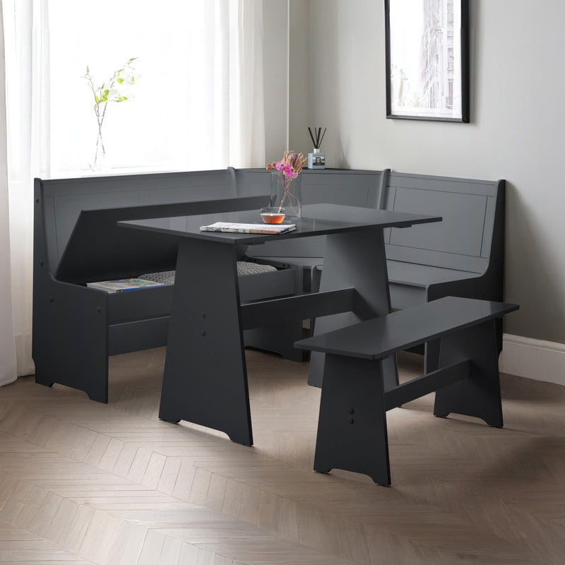 Black dining set with bench seating in a room with light-colored walls and wooden floor.