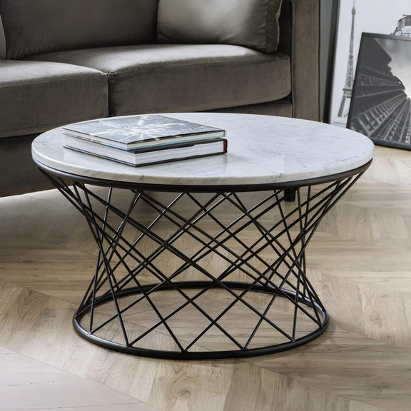 Round marble coffee table with black metal base in a living room setting