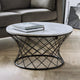 Round marble coffee table with black metal base in a living room setting