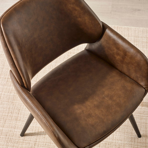Brown leather chair on a textured beige floor