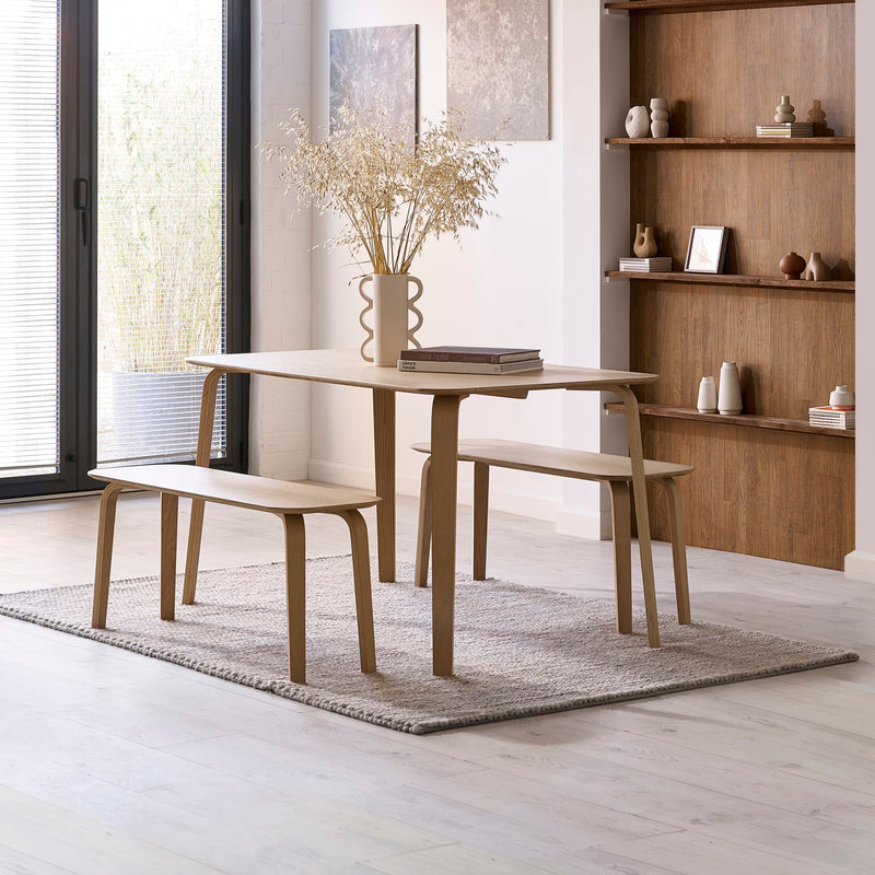 Dining area with wooden table and benches in a modern interior setting.