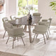 Dining room with a round glass table and eight chairs in a bright room.