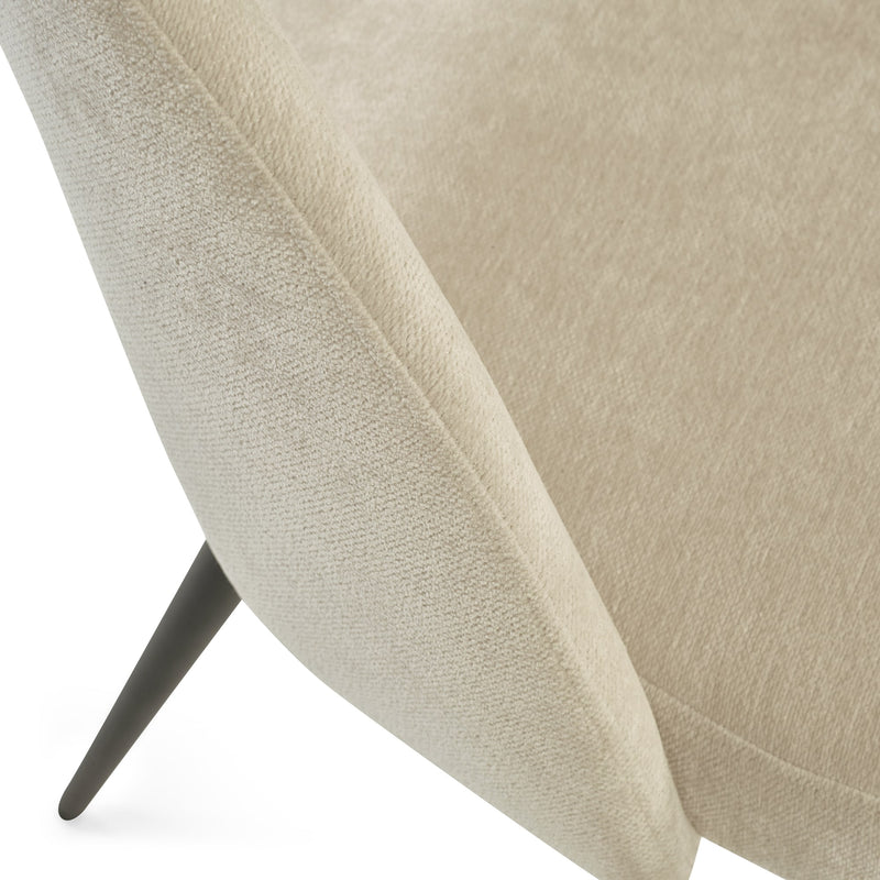 Close-up of a beige upholstered chair with a textured fabric finish.