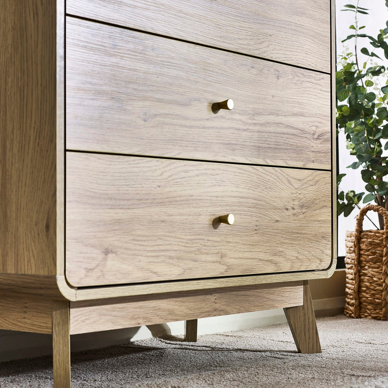 Wooden dresser with two drawers and a plant in the background