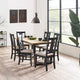 Dining room with wooden table and chairs near a large window.