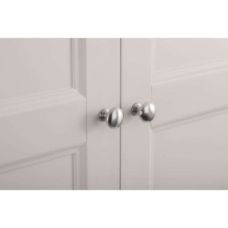 Close-up of a light gray cabinet with silver knobs on a white background