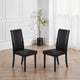 Two black chairs on a wooden floor with a plant in the background.