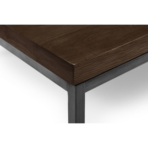 Wooden table corner with dark brown surface and metal frame on a white background