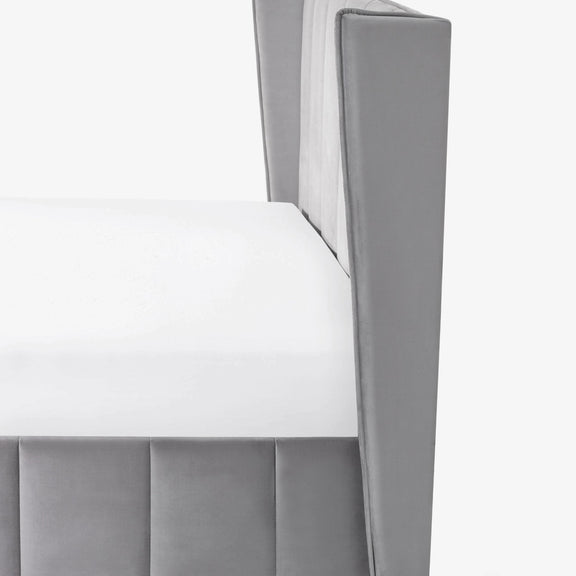 Gray upholstered chair with a white cushion on a light gray background