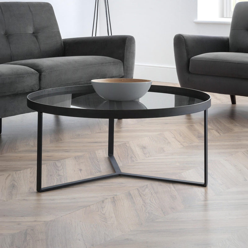 Modern living room with a black coffee table and gray sofa.