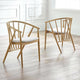 Two wooden chairs with white cushions on a light wooden floor.