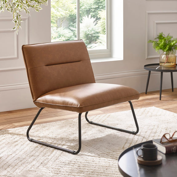 Brown leather chair in a modern living room with a window and decor.