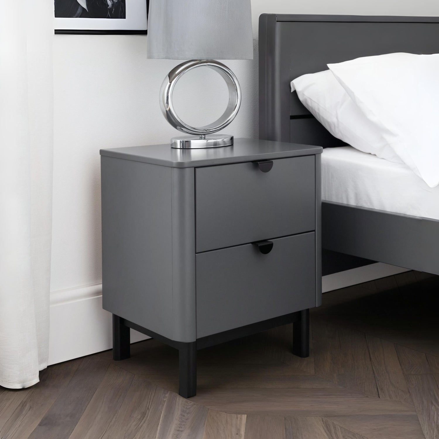 Gray nightstand with a mirror next to a bed in a bedroom setting