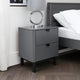 Gray nightstand with a mirror next to a bed in a bedroom setting