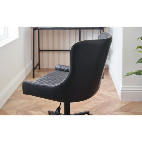 Black office chair in a room with a desk and plant