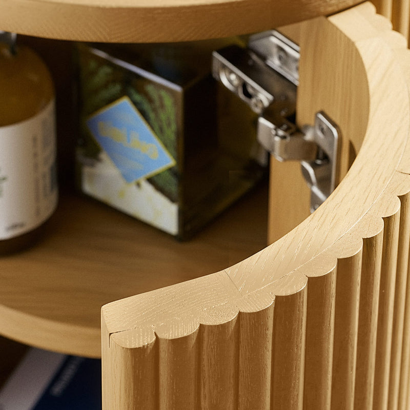 Close-up of a wooden shelf with a hinge and tea box in the background