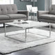 Modern living room with gray sofas, a glass coffee table, and decorative items.