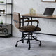 Brown office chair in front of a wooden desk with a laptop, against a white brick wall.