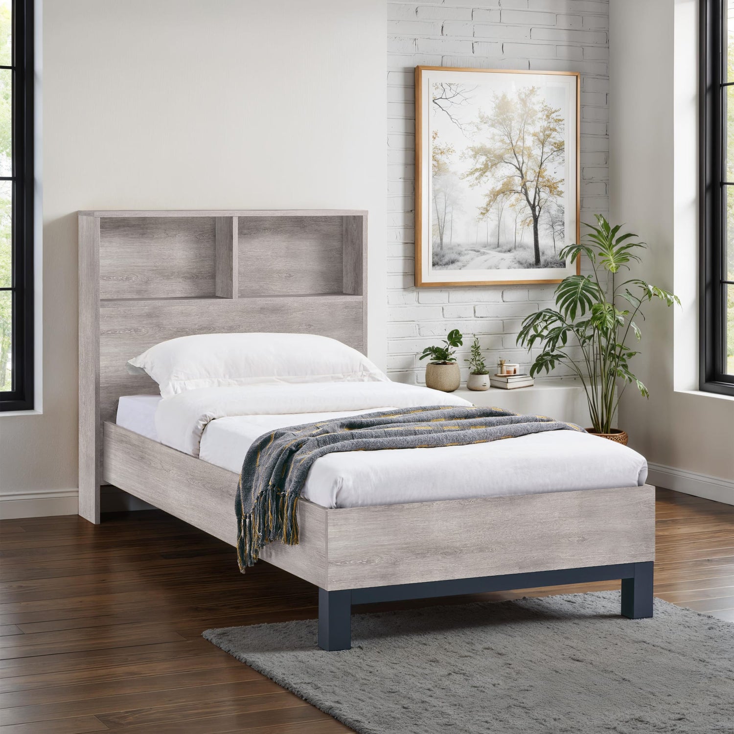 Wooden bed with white bedding in a room with a painting and plants.