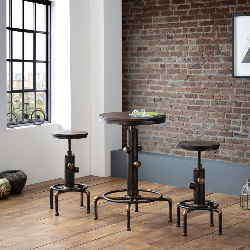 Set of industrial-style stools and a table against a brick wall.