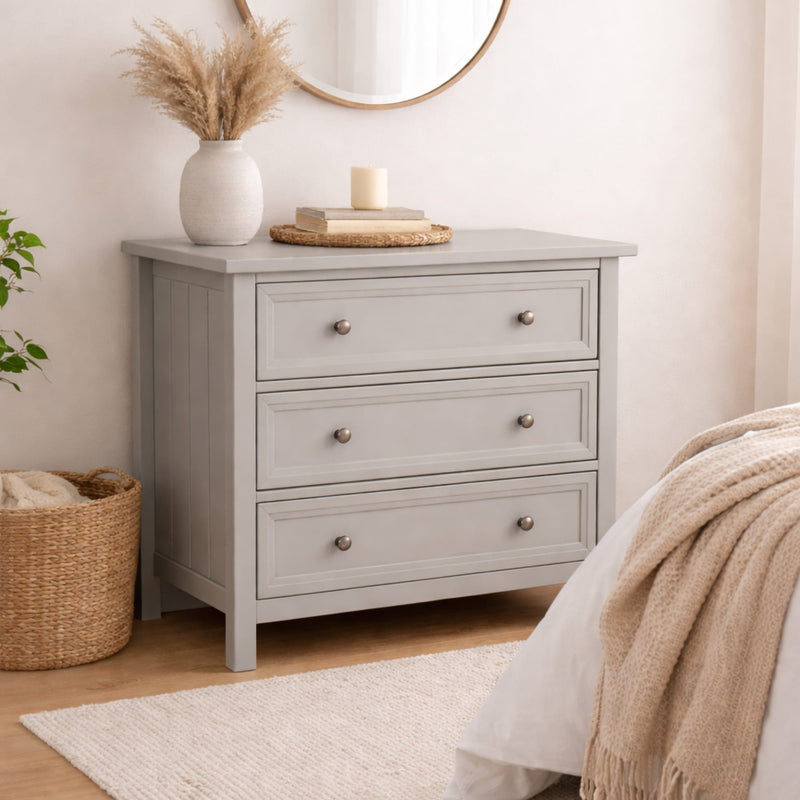 Gray dresser with three drawers in a bedroom setting.