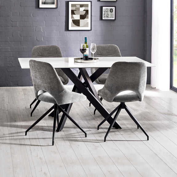 Dining table with four chairs in a modern room with gray walls and a window.