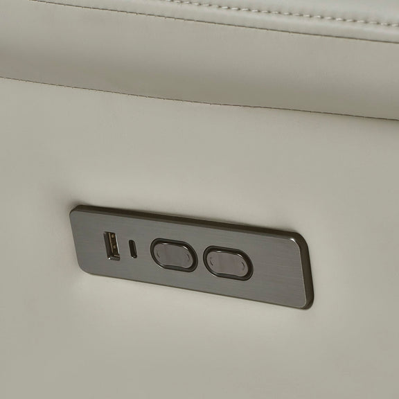 Close-up of a power outlet with USB port and two sockets on a beige wall.