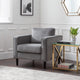 Gray armchair in a living room with a side table and decorative items.