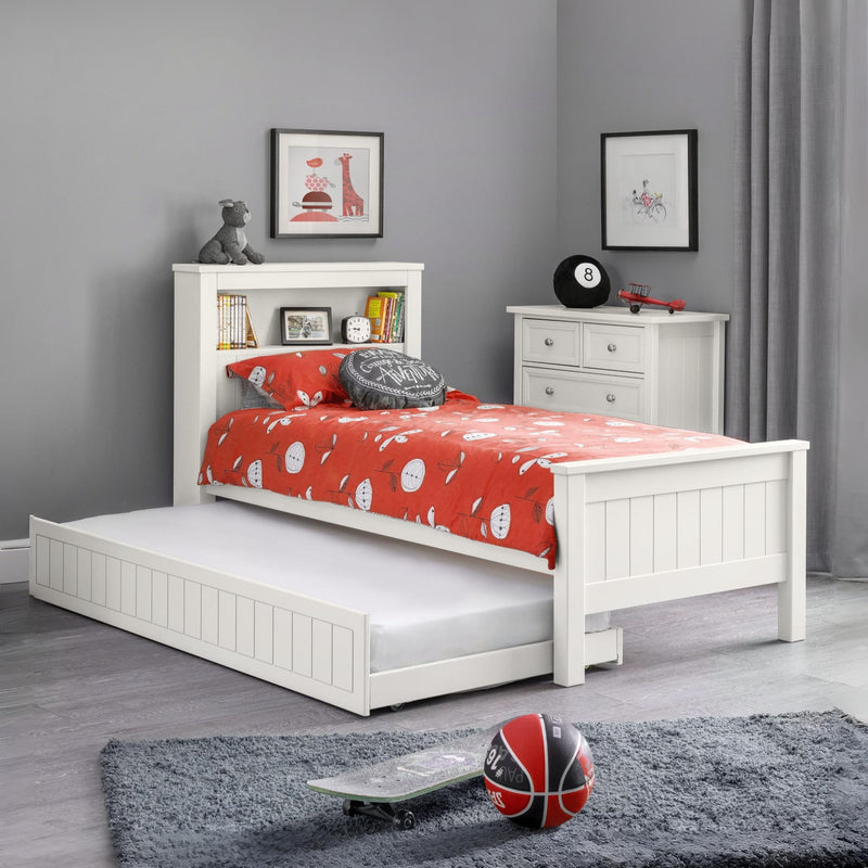 White bed with red bedding in a room with gray walls and a rug.