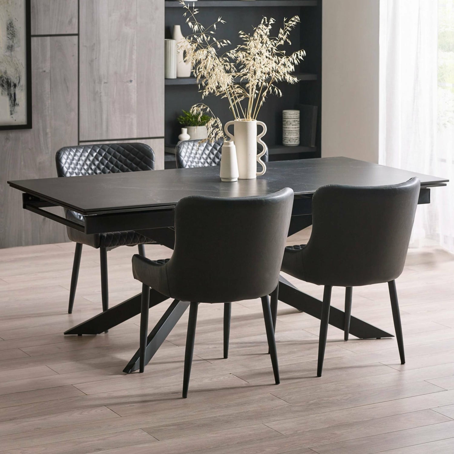 Dining room with a black dining table and chairs in a modern interior setting.