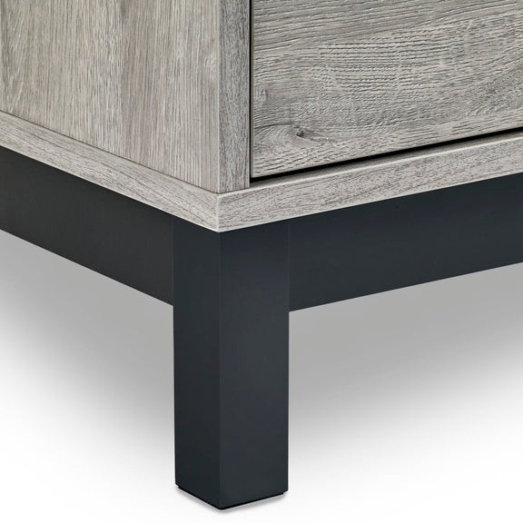 Close-up of a wooden cabinet with a black metal leg on a white background