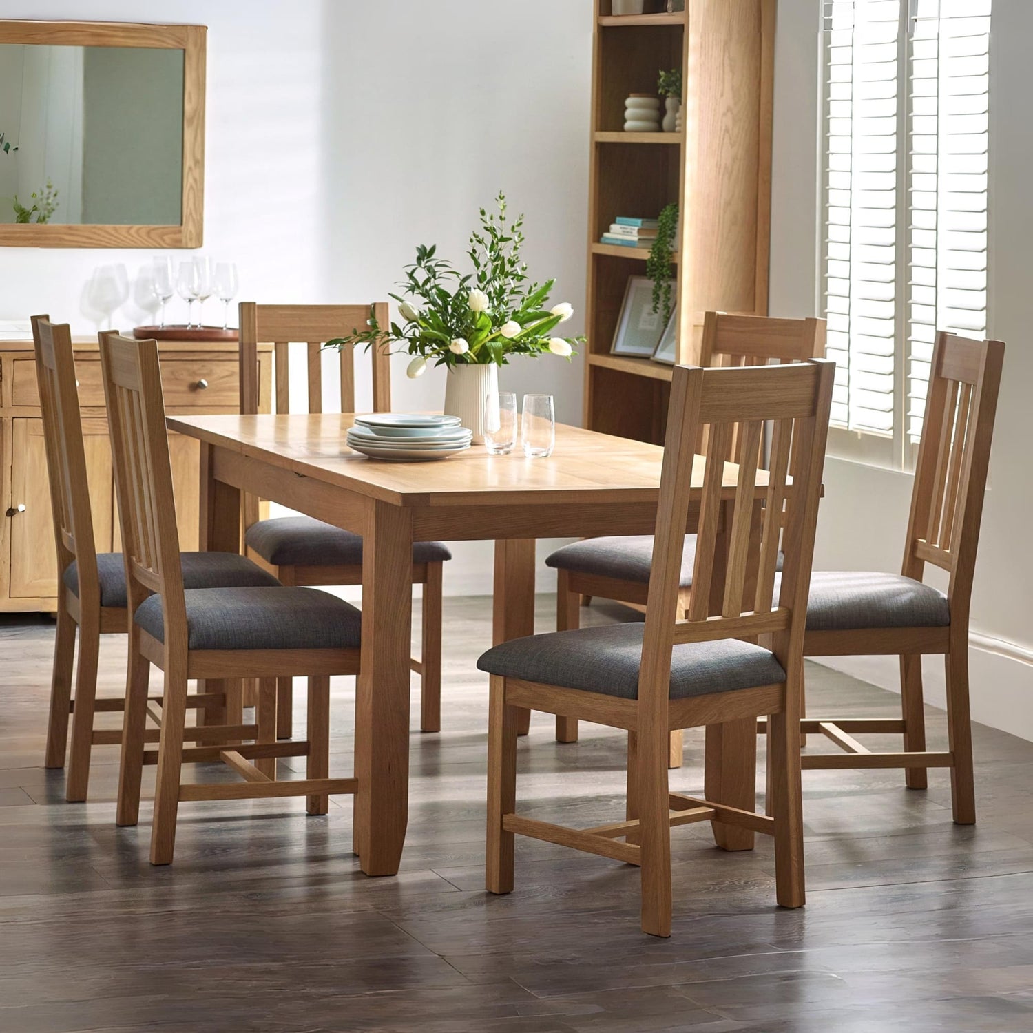 Dining room with wooden table and chairs in a well-lit room.