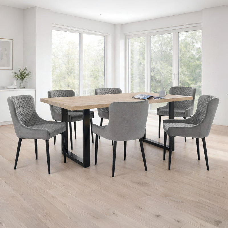 Dining room with a wooden table and gray chairs in a bright room.