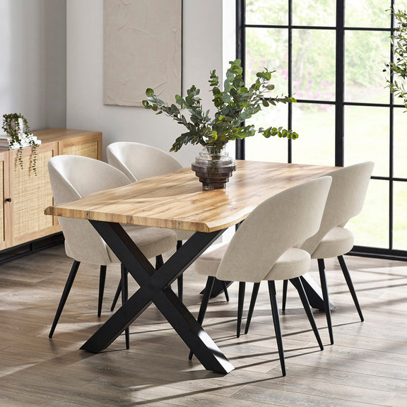 Dining room with a wooden table and white chairs near large windows.