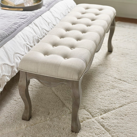 Tufted bench with a cushioned seat in a bedroom setting